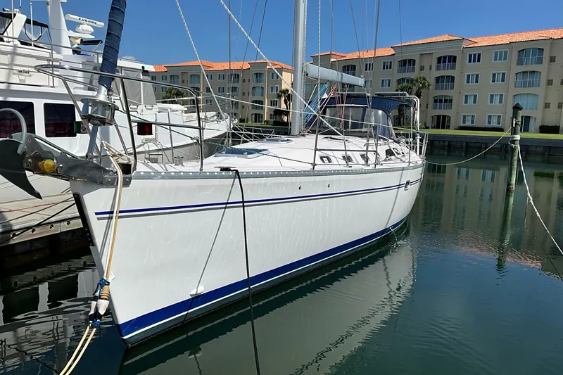Slide: The Image of Sailboat Catalina 470, 2000 model, docked in a marina with waterfront buildings. - 1