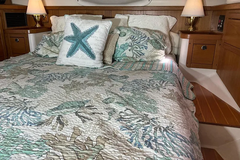 Slide: The Image of Cozy Catalina 470 yacht bedroom with nautical-themed bedding and warm lighting, year 2000 model. - 15