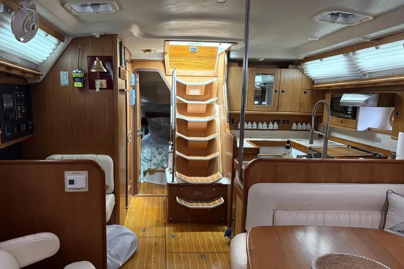 Slide: The Image of Interior of a 2000 Catalina 470 yacht with wooden finishes and cozy seating area. - 7