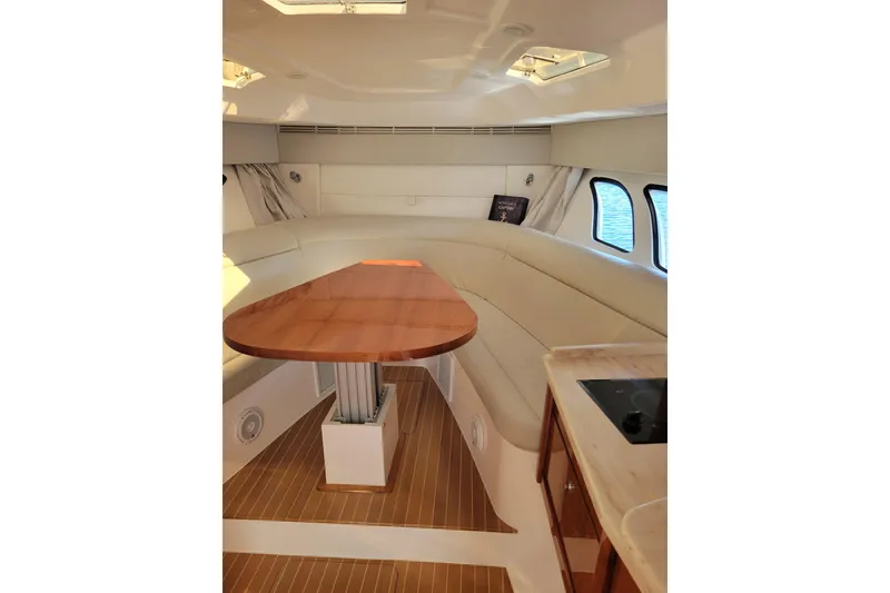 Slide: The Image of Interior of 2016 Intrepid 475 Sport Yacht with elegant seating and wooden table. - 16