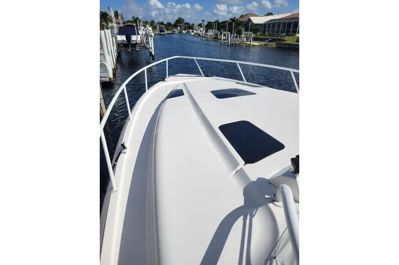 Slide: The Image of 2016 Intrepid 475 Sport Yacht on a sunny marina, showcasing sleek deck design. - 21