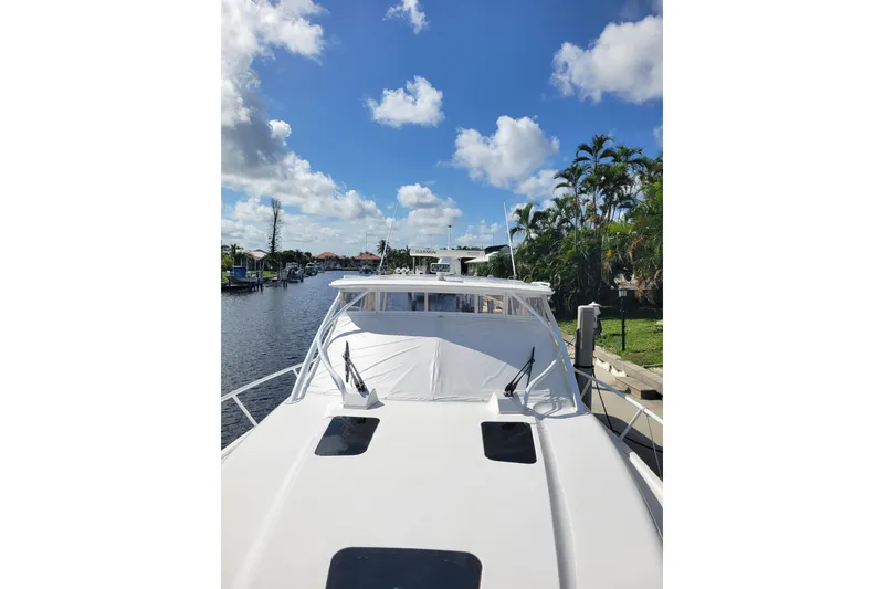 Slide: The Image of 2016 Intrepid 475 Sport Yacht docked under a clear blue sky. - 23