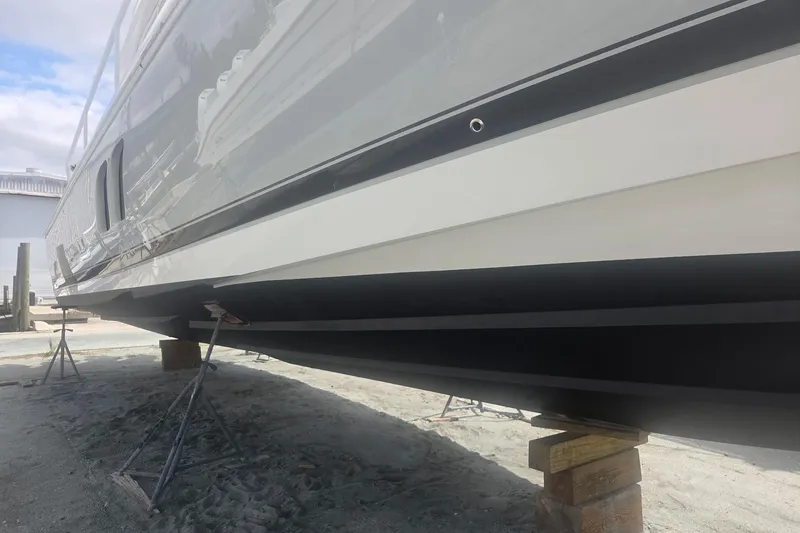 Slide: The Image of 2016 Intrepid 475 Sport Yacht on stands, showcasing sleek hull design. - 26