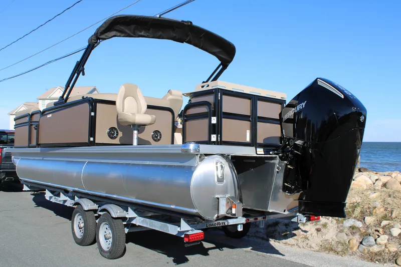 Slide: The Image of 2026 Premier 230 Sunsation Angler 2pt pontoon boat on trailer by the sea. - 2