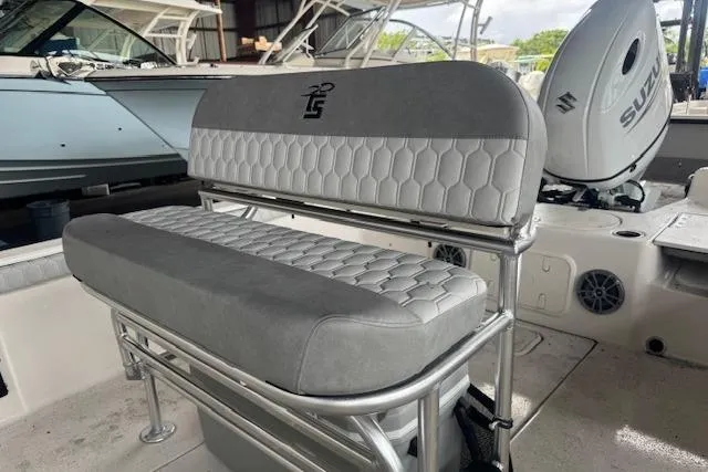Slide: The Image of 2026 Carolina Skiff 25 LS boat interior with gray seating and Suzuki outboard motor. - 10