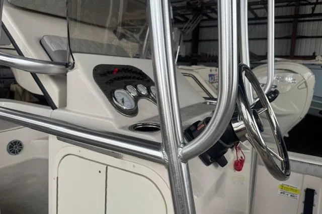 Slide: The Image of 2026 Carolina Skiff 25 LS boat console with steering wheel and gauges in a storage facility. - 11