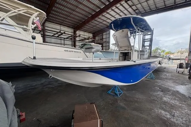 Slide: The Image of 2026 Carolina Skiff 25 LS boat in storage, featuring a blue and white hull. - 12