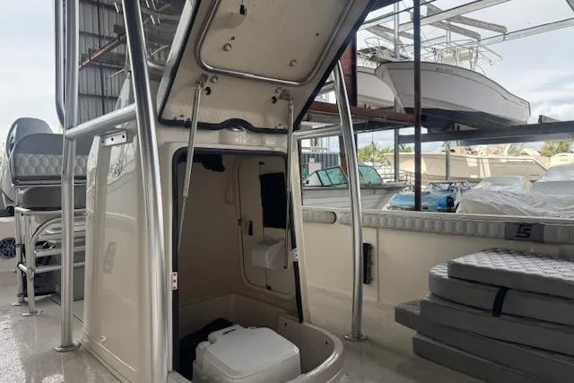 Slide: The Image of 2026 Carolina Skiff 25 LS boat interior with storage and seating in a marina setting. - 16