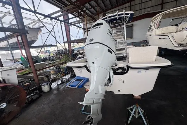 Slide: The Image of 2026 Carolina Skiff 25 LS boat with outboard motor in a covered marina. - 5