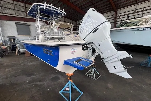 Slide: The Image of 2026 Carolina Skiff 25 LS boat in a warehouse, elevated on stands. - 6