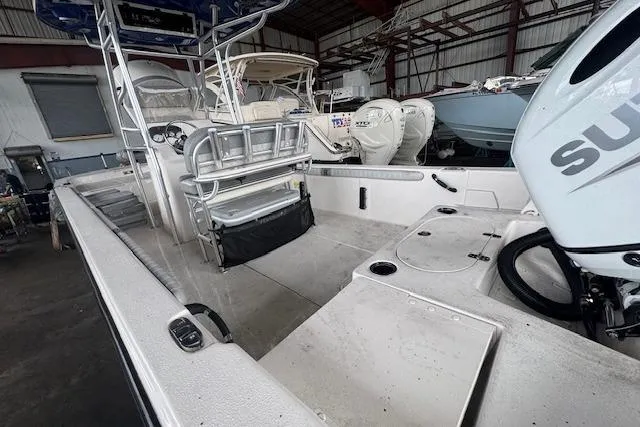 Slide: The Image of 2026 Carolina Skiff 25 LS boat interior with seating and motor in a storage facility. - 7