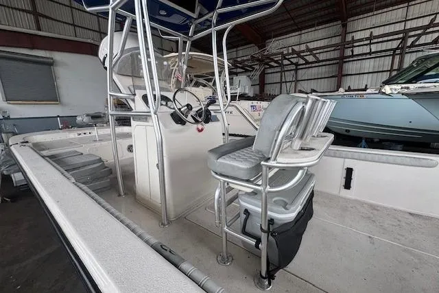 Slide: The Image of 2026 Carolina Skiff 25 LS boat interior with helm and seating in a storage facility. - 8