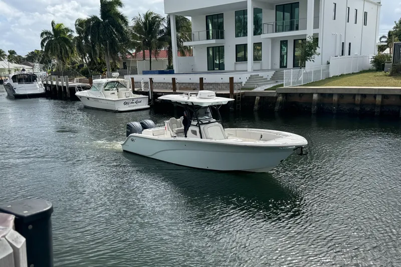The Image of 2022 Sea Fox 288 Commander boat cruising in a canal near modern waterfront homes. - 0