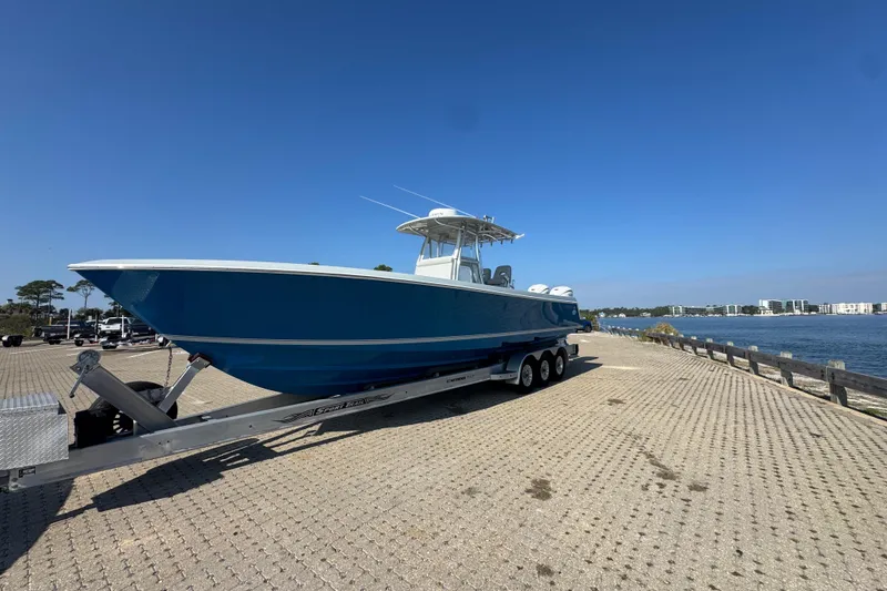 Slide: The Image of 2016 Contender 35 ST boat on trailer by waterfront, clear blue sky. - 2