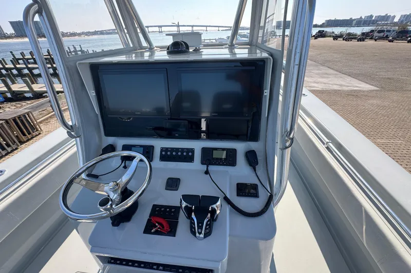 Slide: The Image of 2016 Contender 35 ST boat console with dual screens and steering wheel, dockside view. - 7