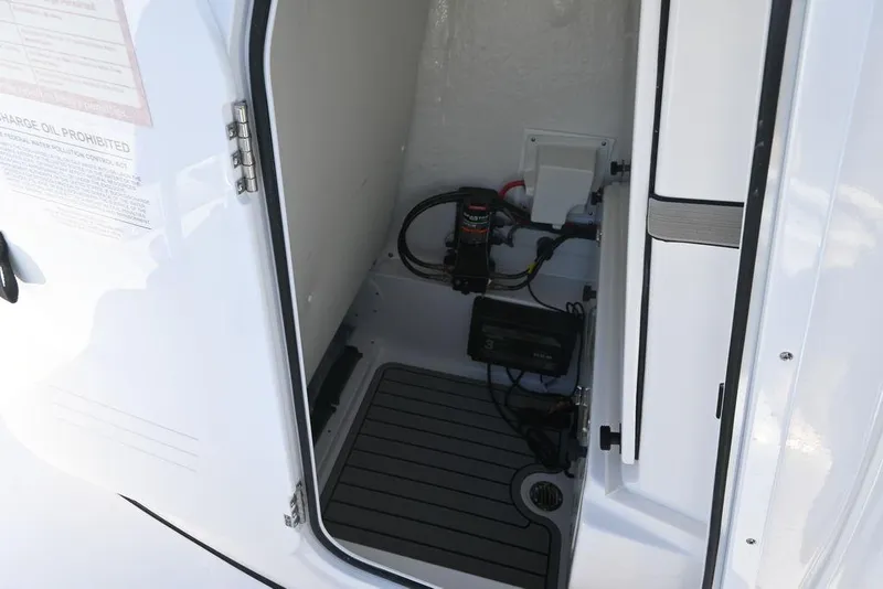 Slide: The Image of 2026 Tidewater 2500 Carolina Bay boat storage compartment with electrical components and wiring. - 18