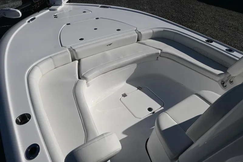 Slide: The Image of 2026 Tidewater 2500 Carolina Bay boat interior with white cushioned seating and storage compartments. - 22