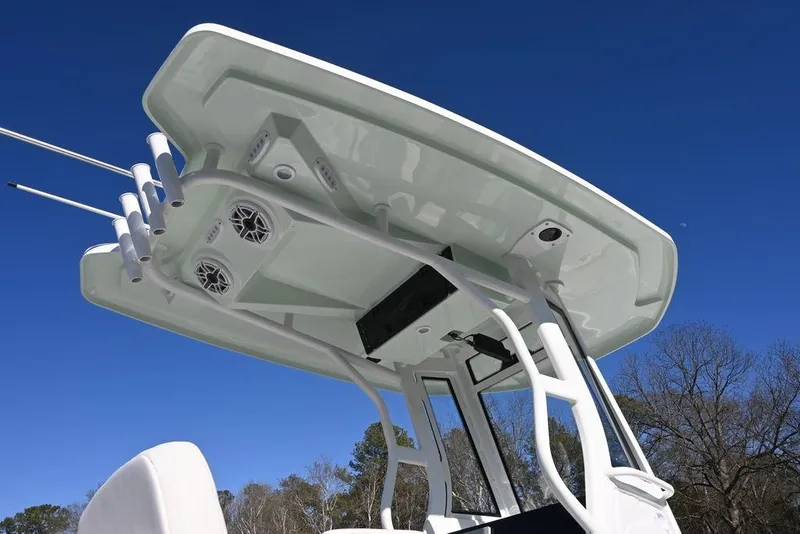 Slide: The Image of 2026 Tidewater 2500 Carolina Bay boat with T-top and rod holders against clear blue sky. - 3