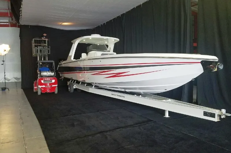 Slide: The Image of 2017 Cigarette 39' GTS boat on trailer in indoor setting with forklift nearby. - 1