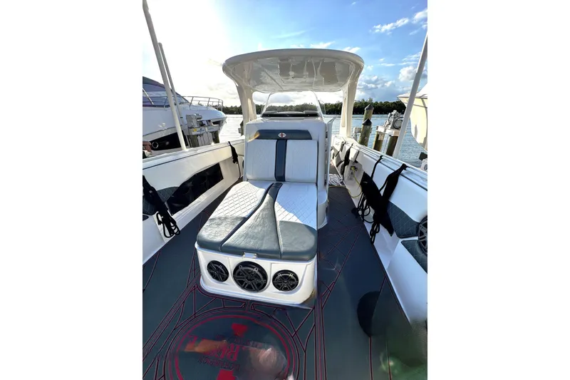 Slide: The Image of 2017 Cigarette 39' GTS boat interior with seating and speakers, docked by the water. - 9