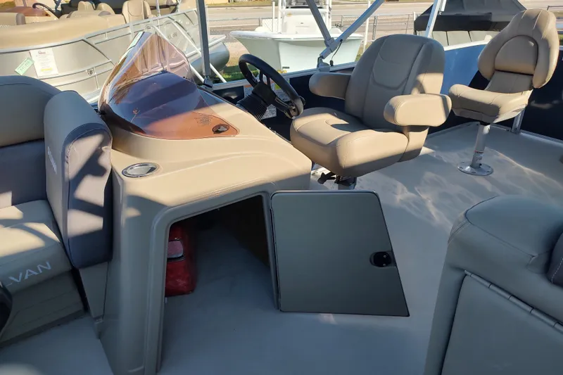 Slide: The Image of 2023 Sylvan Mirage 8520 Party Fish boat interior with beige seating and steering console. - 16