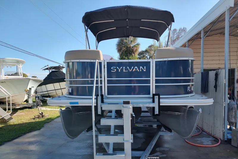 Slide: The Image of 2023 Sylvan Mirage 8520 Party Fish pontoon boat on a lift, outdoor setting. - 7