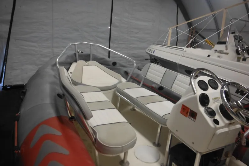 Slide: The Image of 2014 Zodiac Pro 550 inflatable boat with seating and control console in storage. - 6