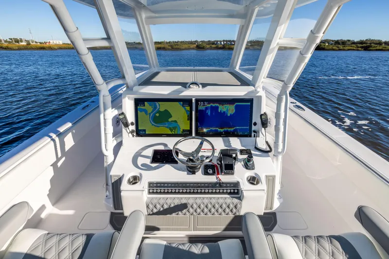 Slide: The Image of 2026 Invincible 38 Catamaran cockpit with advanced navigation displays on open water. - 11