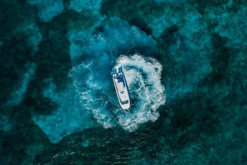 Slide: The Image of Aerial view of 2026 Invincible 38 Catamaran navigating vibrant blue ocean waters. - 19