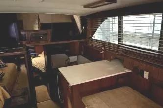 Slide: The Image of Interior of 1977 Hatteras 43 Double Cabin yacht with wood paneling and large windows. - 10