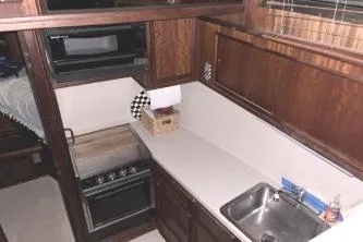 Slide: The Image of 1977 Hatteras 43 Double Cabin kitchen with stove, sink, and microwave. - 12