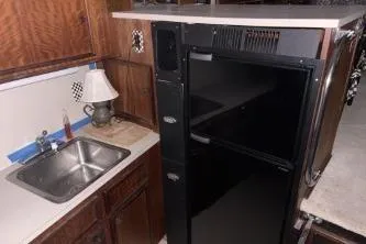 Slide: The Image of 1977 Hatteras 43 Double Cabin kitchen with sink, and black refrigerator/freezer. - 13