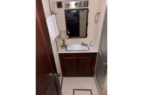Slide: The Image of 1977 Hatteras 43 Double Cabin bathroom with sink, mirror, and shower. - 14