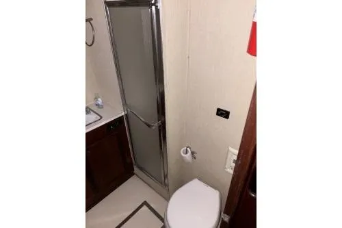 Slide: The Image of 1977 Hatteras 43 Double Cabin bathroom with shower, sink, and toilet. - 15