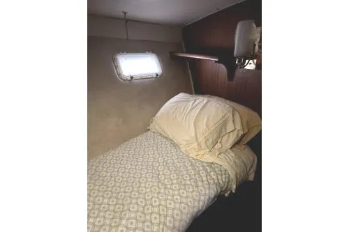 Slide: The Image of 1977 Hatteras 43 Double Cabin interior with cozy bed and porthole window. - 17