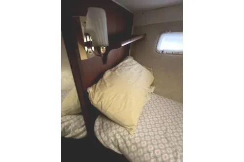 Slide: The Image of 1977 Hatteras 43 Double Cabin interior with cozy bed and window view. - 18