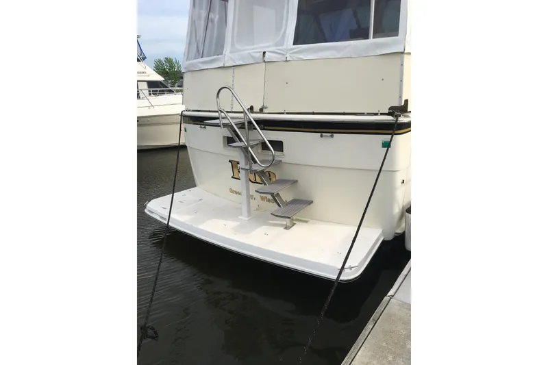 Slide: The Image of 1977 Hatteras 43 Double Cabin yacht with rear deck and ladder in marina. - 4