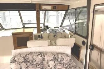 Slide: The Image of 1977 Hatteras 43 Double Cabin interior with floral sofa and helm station. - 5
