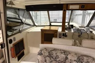 Slide: The Image of 1977 Hatteras 43 Double Cabin interior with helm, seating, and floral-patterned sofa. - 8