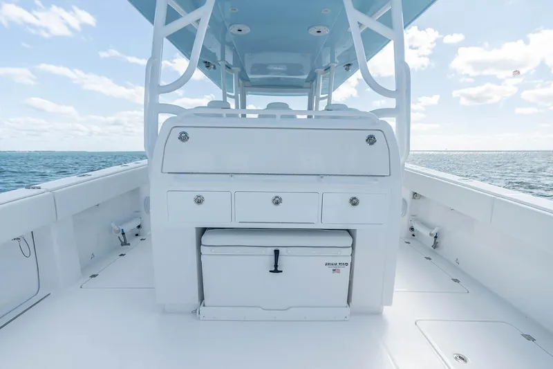 Slide: The Image of Manufacturer Provided Image: 2026 Invincible 40 Catamaran deck with storage and cooler, set against ocean backdrop. - 7