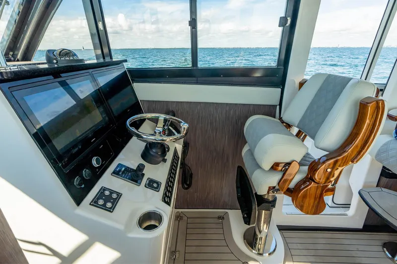 Slide: The Image of Pilothouse interior of 2026 Invincible 46, featuring modern controls and luxurious seating. - 16