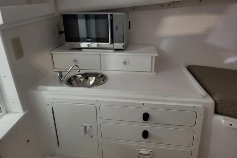 Slide: The Image of 2020 Steiger Craft 31 Miami boat interior with sink, microwave, and storage. - 28