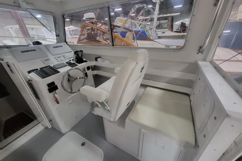 Slide: The Image of 2020 Steiger Craft 31 Miami boat interior with steering wheel and seating area. - 38