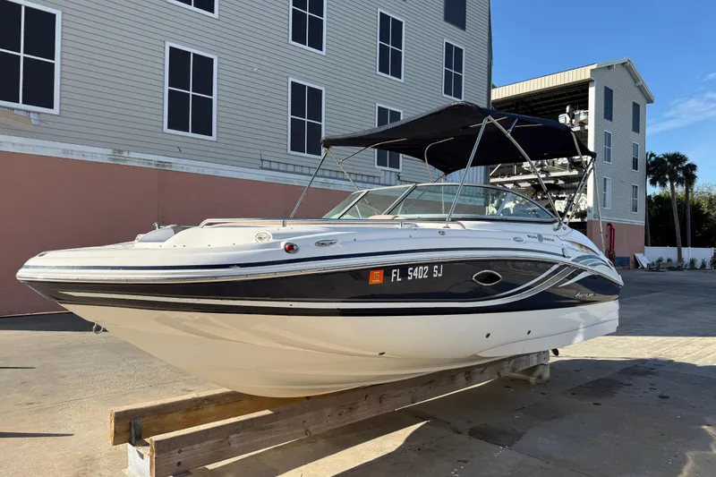 Slide: The Image of 2015 Hurricane SunDeck 2000 OB boat on display outside a building. - 1