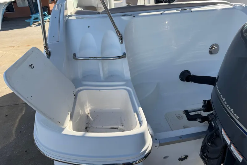 Slide: The Image of 2015 Hurricane SunDeck 2000 OB boat with open storage compartment and outboard motor. - 11