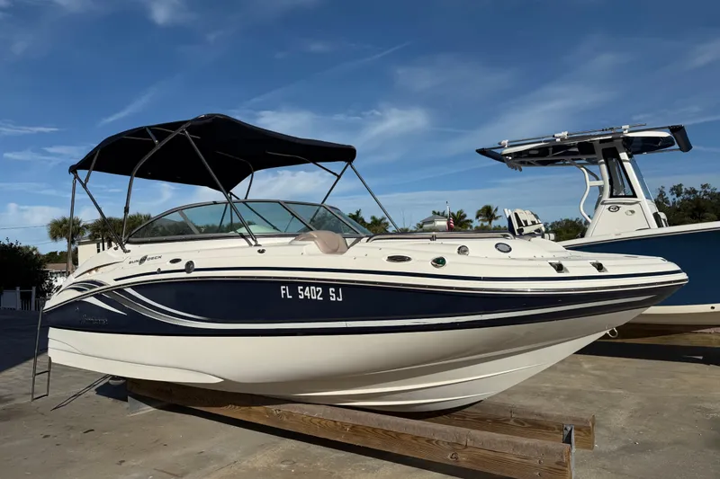 Slide: The Image of 2015 Hurricane SunDeck 2000 OB boat with canopy, docked under clear blue sky. - 2