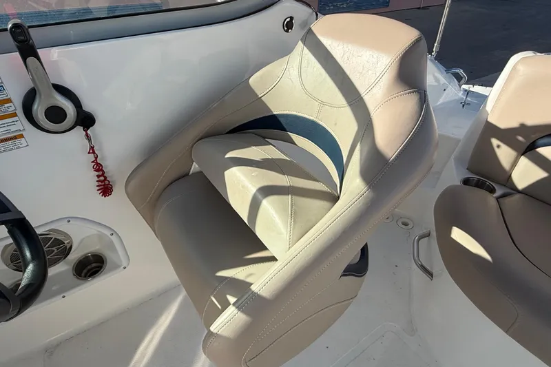 Slide: The Image of 2015 Hurricane SunDeck 2000 OB boat interior with beige seating and control panel. - 26