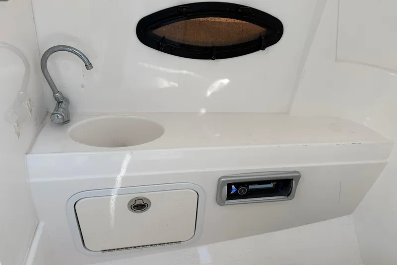 Slide: The Image of 2015 Hurricane SunDeck 2000 OB boat interior with sink and storage compartment. - 38