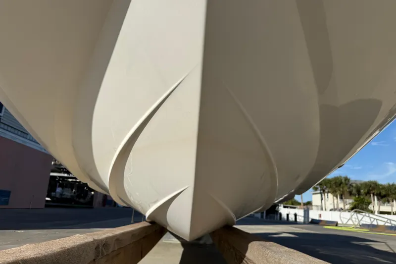 Slide: The Image of 2015 Hurricane SunDeck 2000 OB boat hull on wooden support, outdoor setting. - 6