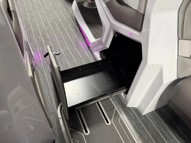 Slide: The Image of An open storage compartment with a drawer on a boat with gray flooring. - 44